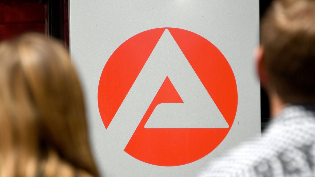 Zwei Personen stehen vor dem Logo der Agentur für Arbeit