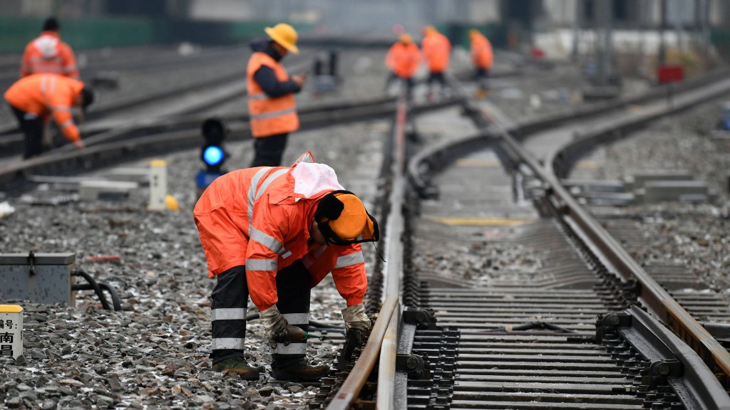 Foto: Angestellte beim Arbeiten an Eisenbahnschienen