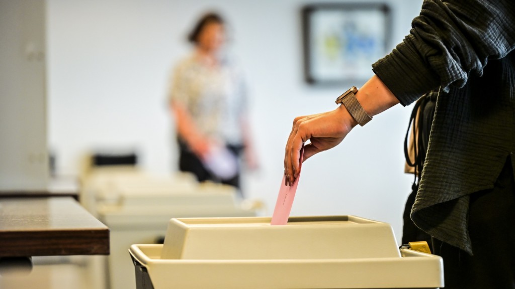 Foto: Eine Person wirft ihren Stimmzettel in eine Wahlurne in einem Wahlbüro