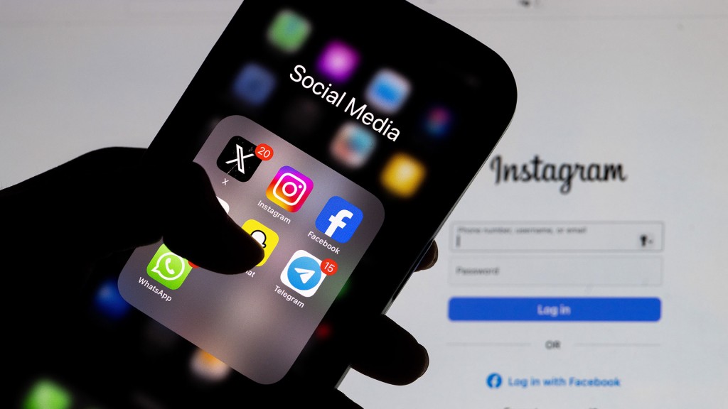 Der Anmeldebildschirm von Instagram wird auf einem Laptop-Bildschirm angezeigt, und der Social-Media-Ordner wird auf einem Smartphone-Bildschirm angezeigt.