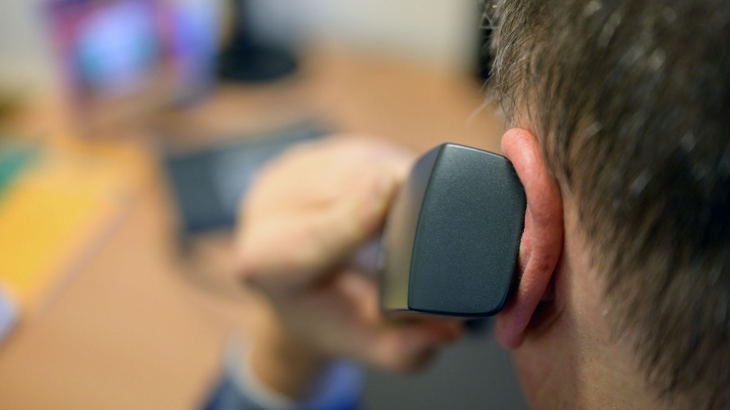 Ein Telefonhörer wird ans Ohr gehalten