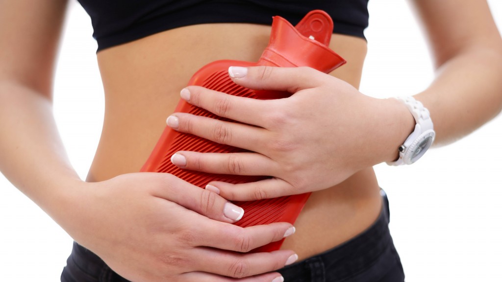 Frau mit einer roten Wärmeflasche vor dem Bauch