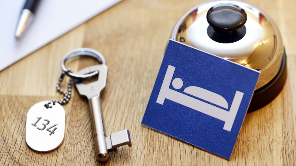 Foto: Ein Zimmerschlüssel liegt neben einer Thekenklingel und einem Bett-Symbol