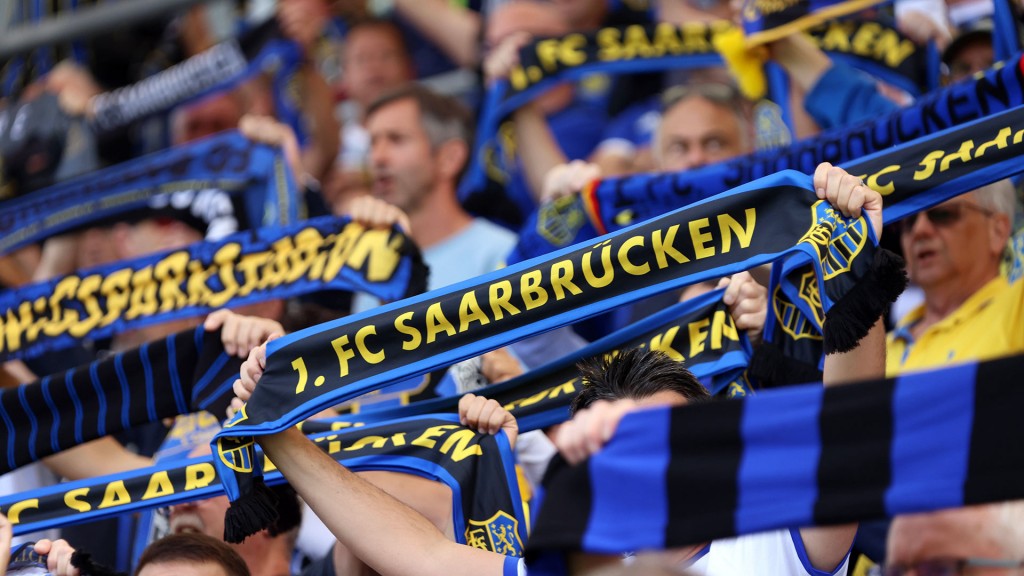 Fans des 1. FC Saarbrücken halten ihre Schals im Stadion hoch